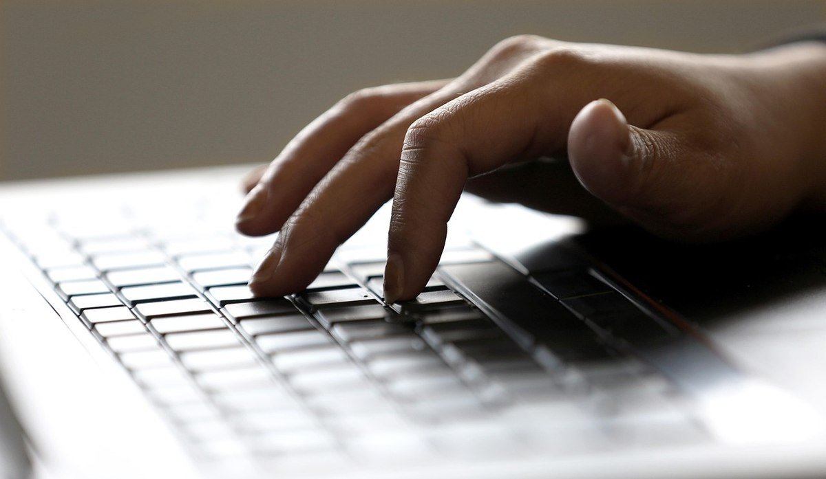 Main reposant sur les touches d'un clavier d'ordinateur