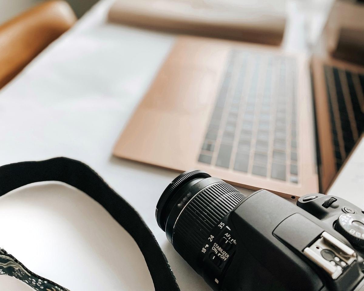 Appareil photo et ordinateur portable sur une table blanche