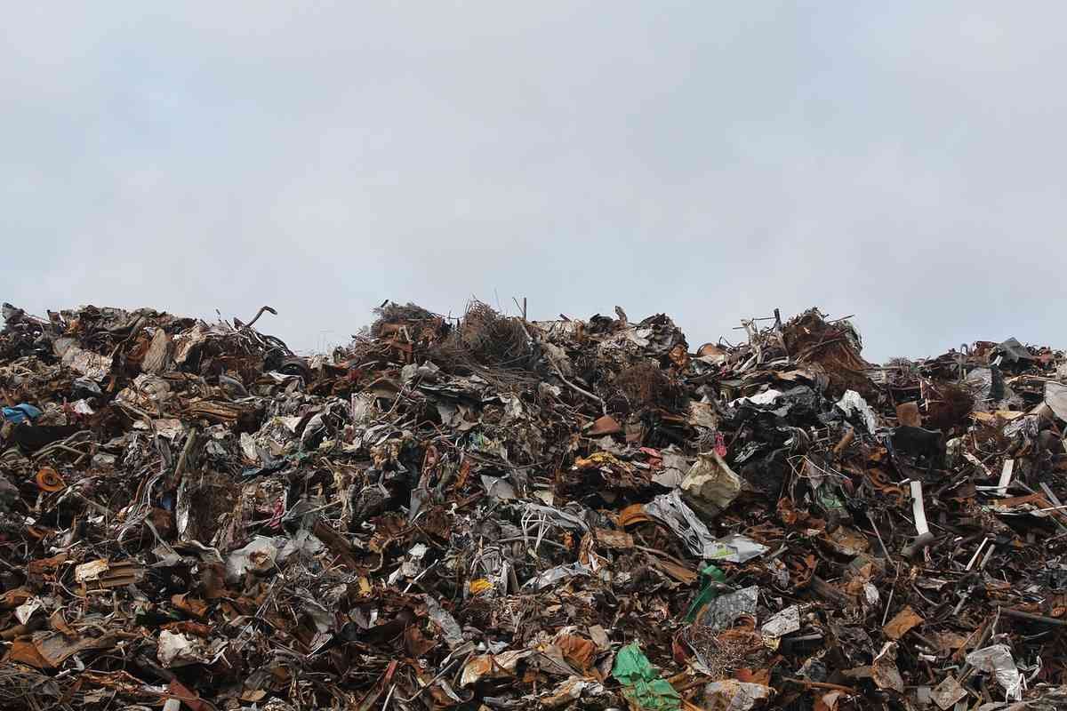 Montagne de déchets variés sous un ciel gris