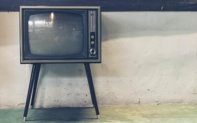Un vieux téléviseur posé sur un support contre un mur