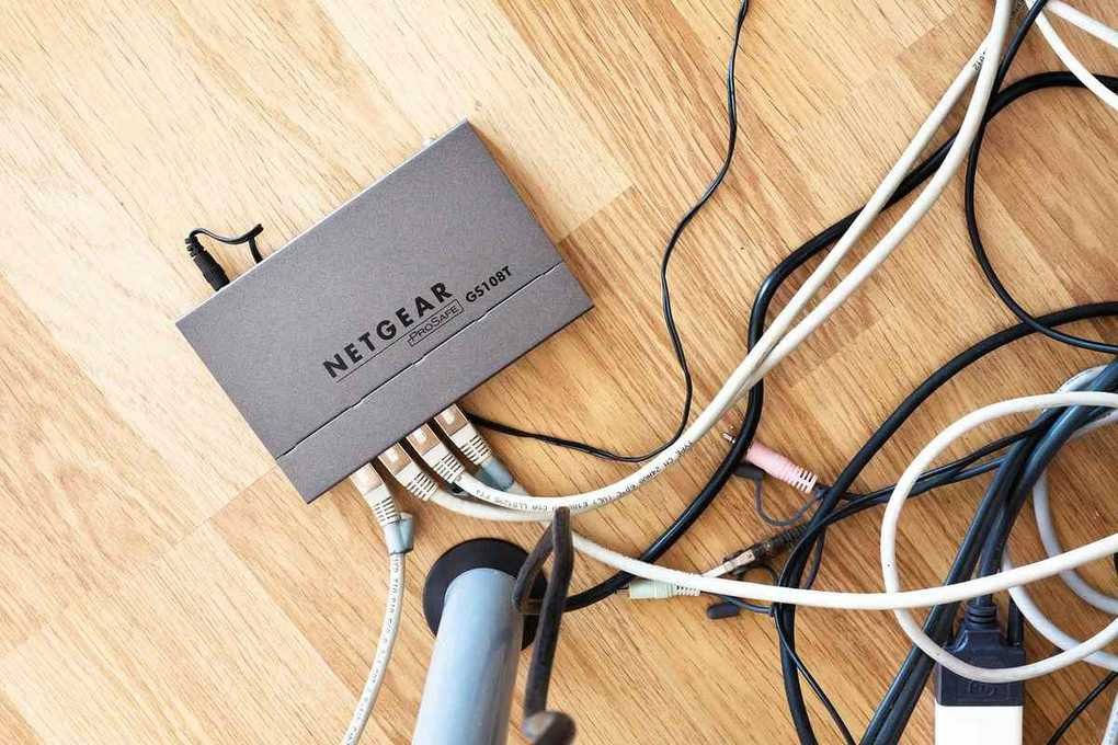 Boîte Netgear connectée à divers câbles sur une surface en bois
